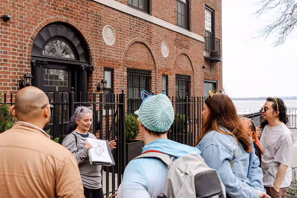 Brooklyn Heights cat history tour stop with guide and guests near brick buildings